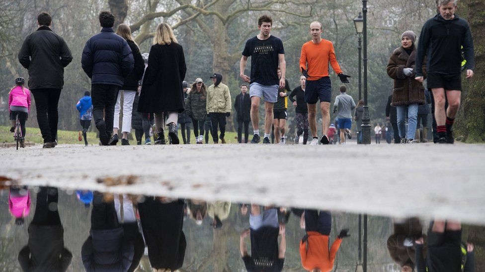 People walk through Battersea Park, London