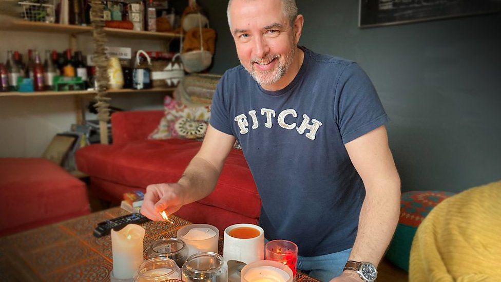 Stephen Holford lights candles in his passive house