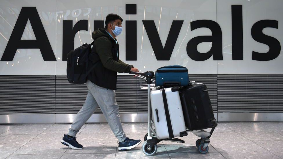 Passenger arriving in Heathrow Airport wearing a face mask