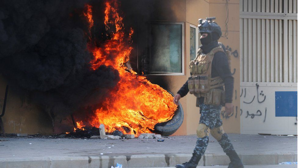 Iraqi security forces by burning tyres outside us embassy