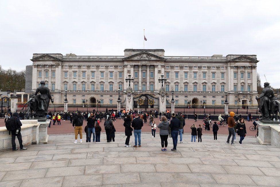 People gather on The Queen Victoria Memorial opposite Buckingham Palace as they pay tribute to Prince Philip, Duke Of Edinburgh who died at age 99 on 10 April 2021 in London