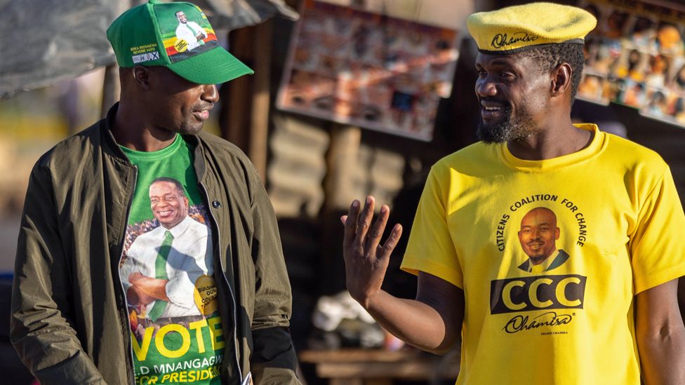 Сторонник правящей партии Zanu-PF (слева) и сторонник Гражданской коалиции за перемены (справа) разговаривают в своих партийных регалиях во время кампании по информированию избирателей о всеобщих выборах 2023 года, проводимой местной организацией гражданского общества 9 августа 2023 года в Хараре. , Зимбабве