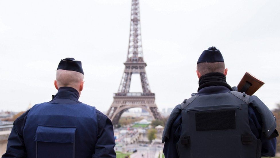 Police officers patrol near the Eiffel tower in Paris