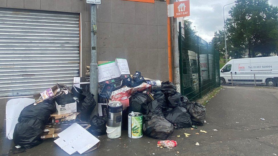 rubbish accumulates outside a business in Drumchapel