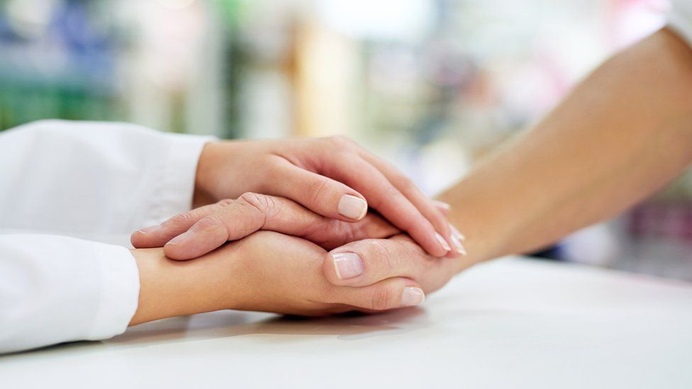 Hands holding resting on a table