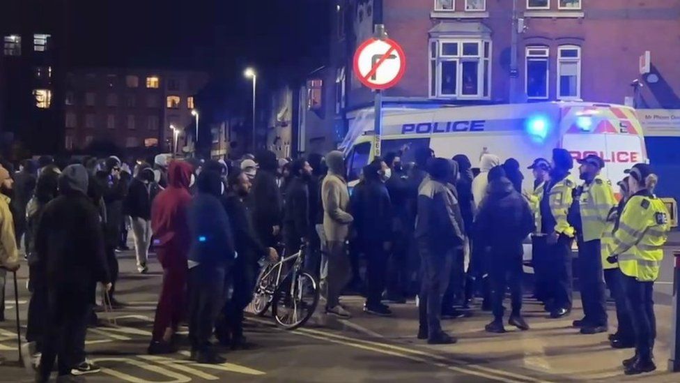 Crowd of people and police officers in Leicester