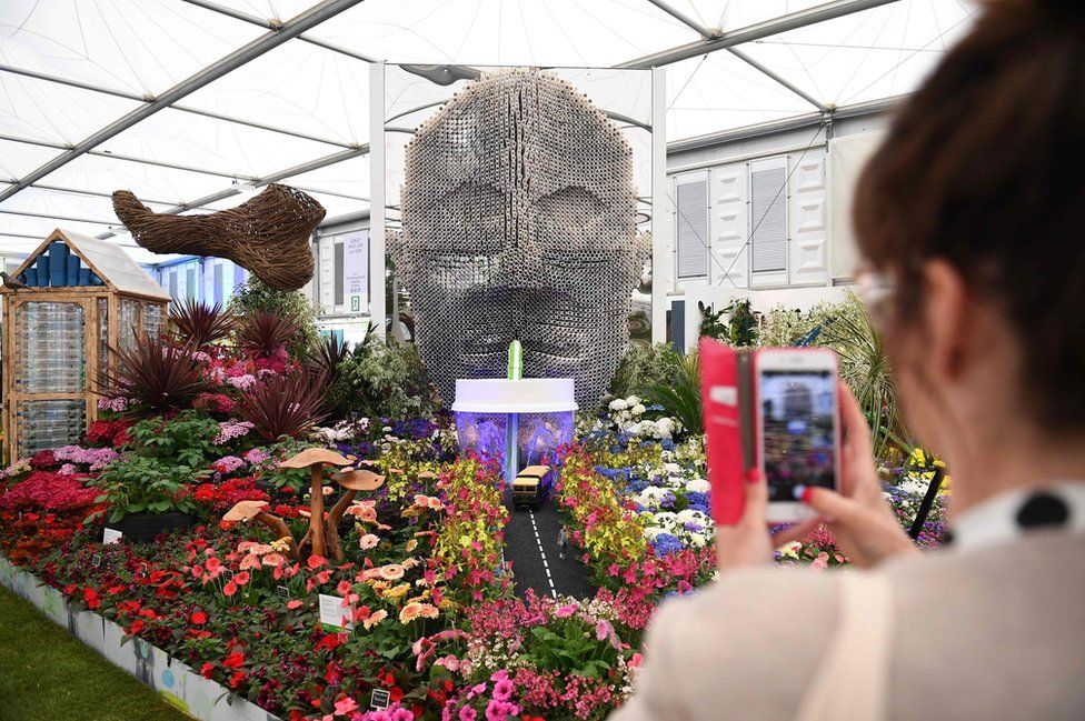 A visitor photographs a display by Baroness Floella Benjamin, called Floella's Future