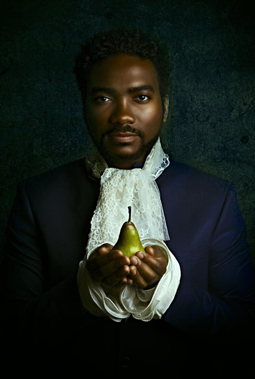 Portrait by Alanna Airitam showing a man holding a pear