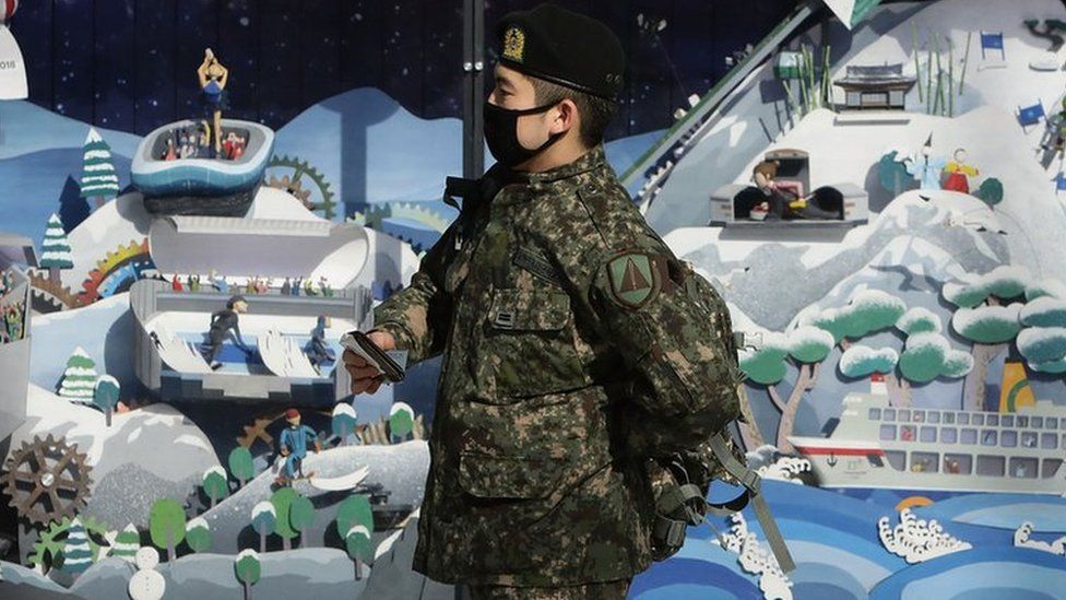 A South Korean soldier walks past the 2018 Pyeongchang Winter Olympic and Paralympic Games PR booth, 5 January 2018