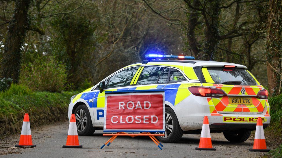 A police car and road closure sign