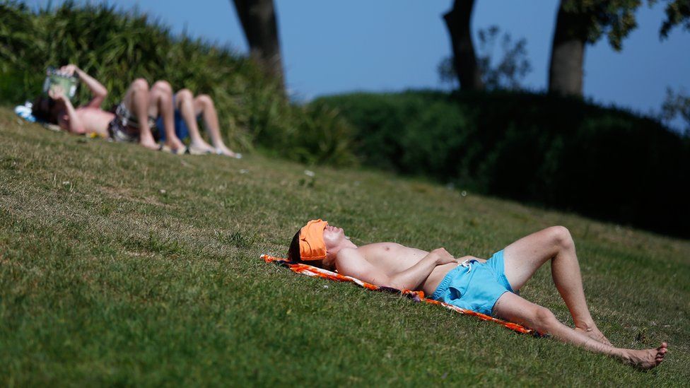 A man lies back with his face covered amid extreme heat at Sydney's Coogee beach earlier this month