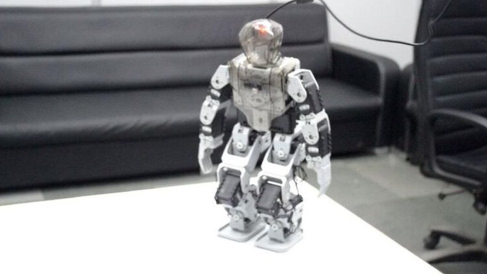A small human-shaped robot on a desk