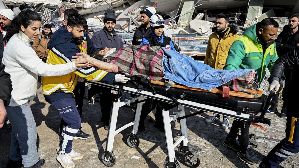 A woman is rescued from under the rubble of a collapsed building in Hatay, Turkey (7 February 2023)