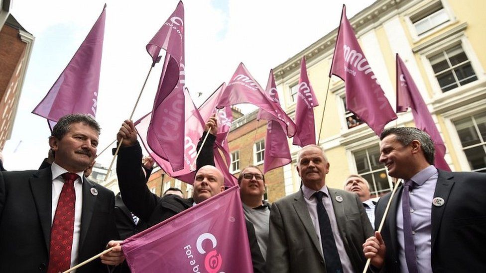 Steelworkers pose for photographers with Community trade union flags as they arrive for a meeting in London