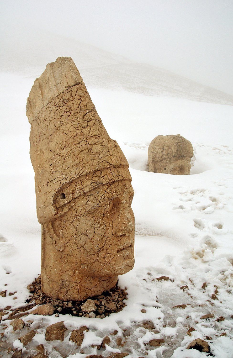 Two stone heads in snow, part of the remains of the Kingdom of Commagene in Turkey