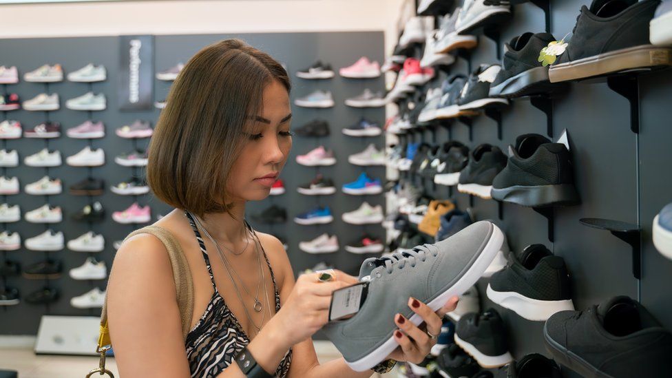 young woman looking at sports shoes