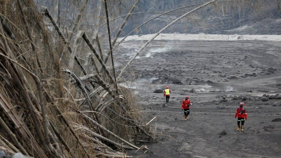 Rescue workers search an area following the eruption of Mount Semeru