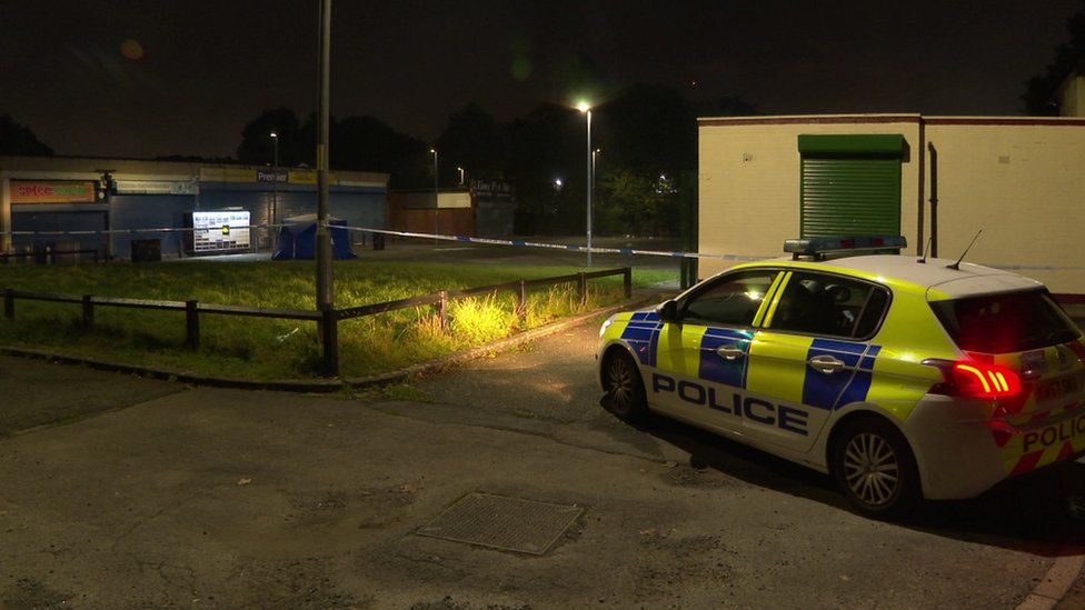 Police cars guard a taped off area of the square