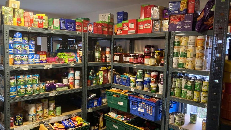 Shelves stocked with tins and packets of food and drink ranging from rice pudding to tea and coffee