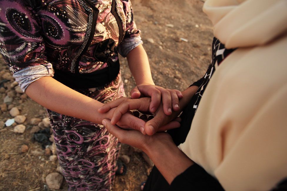 Shaima and Laila hold hands