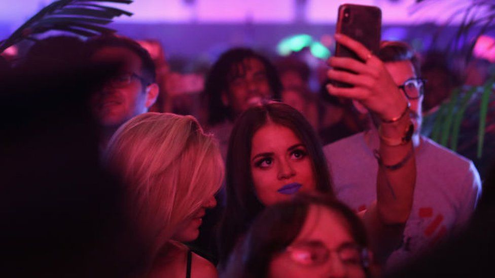 A young woman filming at TikTok's launch party