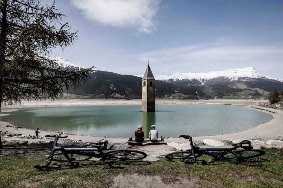 The church spire of the submerged village of Graun protrudes from the Reschensee lake, which has been nearly completely drained, during construction work of a new alpine road on April 29, 2024 near Resia, Italy.