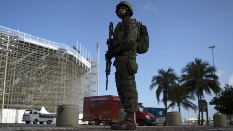 A soldier stands in guard next to the Beach Volleyball venue at the Copacabana Beach in Rio de Janeiro (30 July 2016)