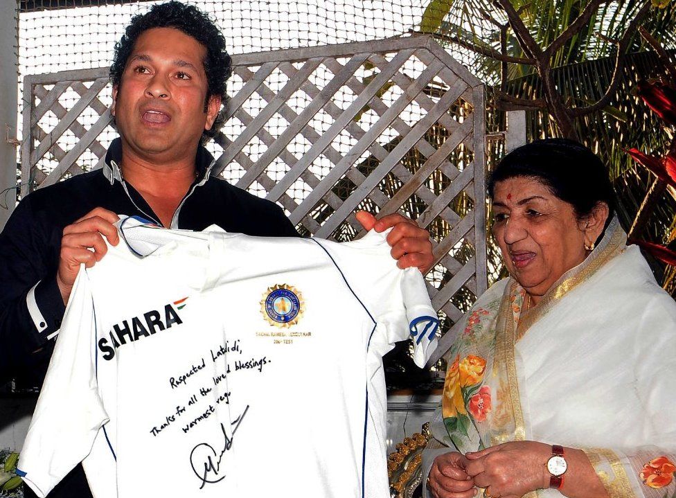 Former Indian cricketer Sachin Tendulkar (L) presents an autographed jersey to Bollywood veteran playback singer Lata Mangeshkar in 2014