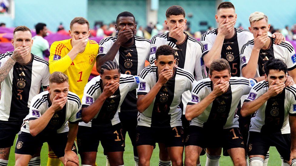 The German team covering their mouths as they pose for a pre-match photo