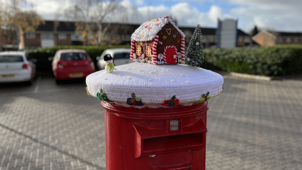 A postbox topper of a gingerbread house