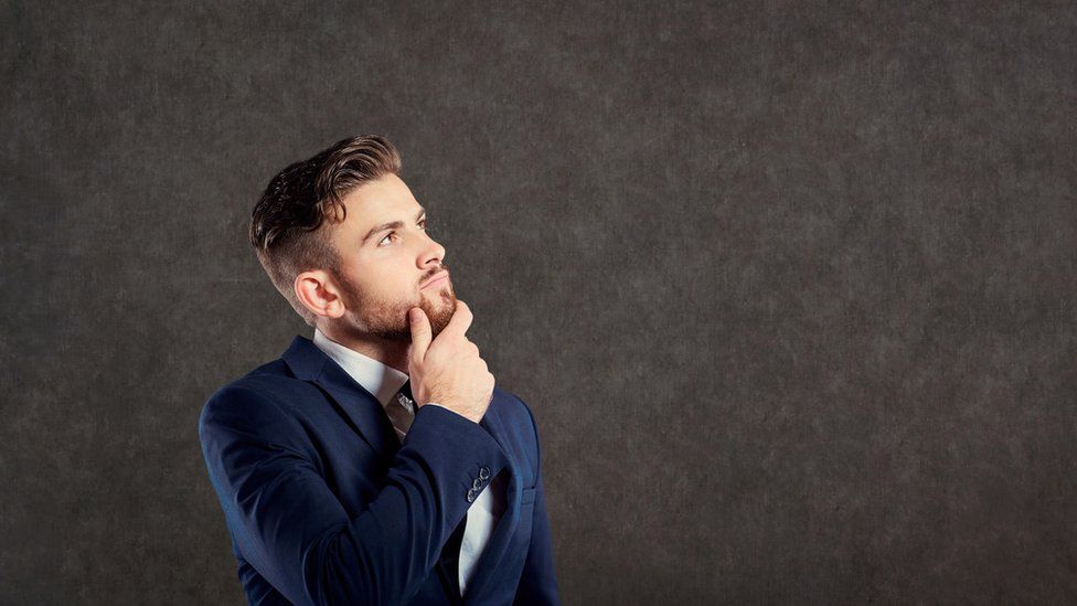 A young businessman in a suit, thinking