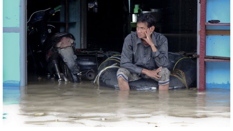 Myanmar man sits in front of the half-flooded building in Kale, Sagaing Region 01/08/2015