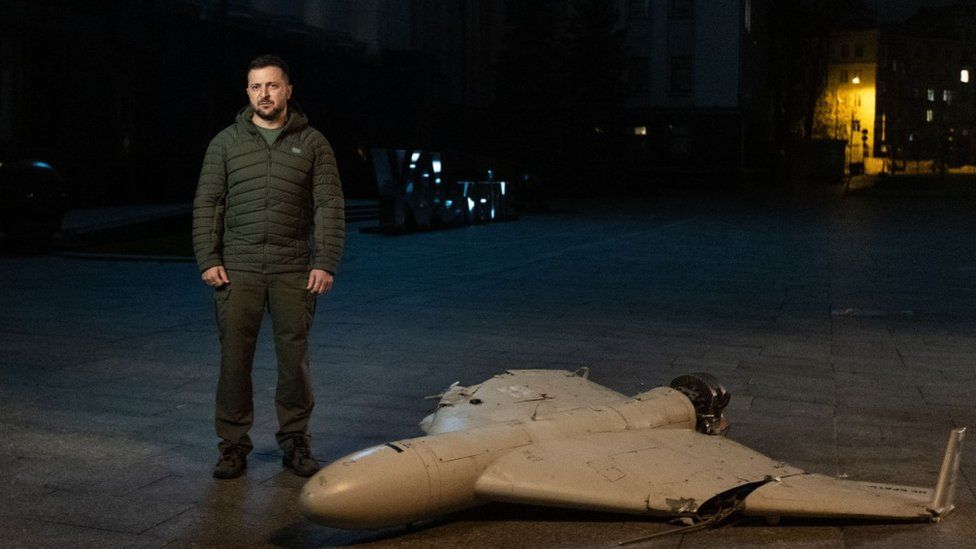 President Volodymyr Zelensky stands beside a downed drone