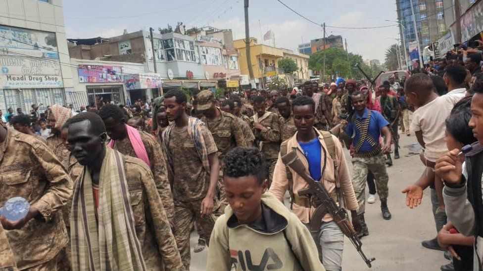 Ethiopian government soldiers and prisoners of war in military uniforms walk through Mekelle, 2 July