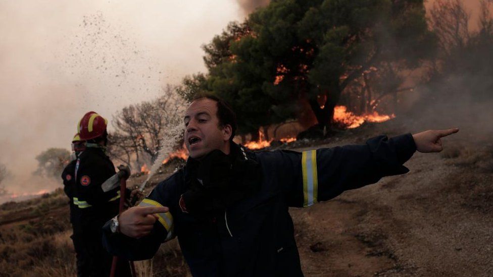 Argyris Makaronas directs his crew while battling flames of a wildfire at the area of Fyli near Athens, Greece, 22 August 2023