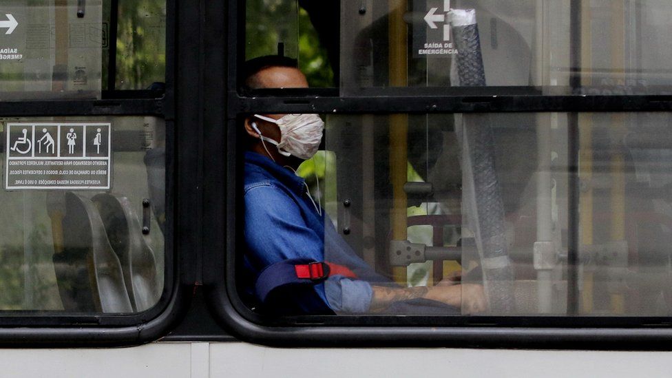 homem com máscara dentro de ônibus.