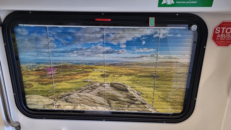 The blinds feature an image of the countryside