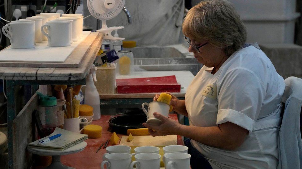 A worker prepares chinaware at a pottery factory in Stoke-on-Trent where the official Coronation chinaware is produced on behalf of Royal Collection Trust