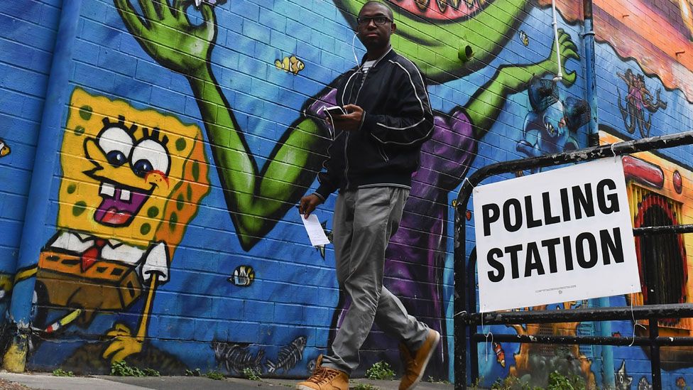 A young man walks past a polling station