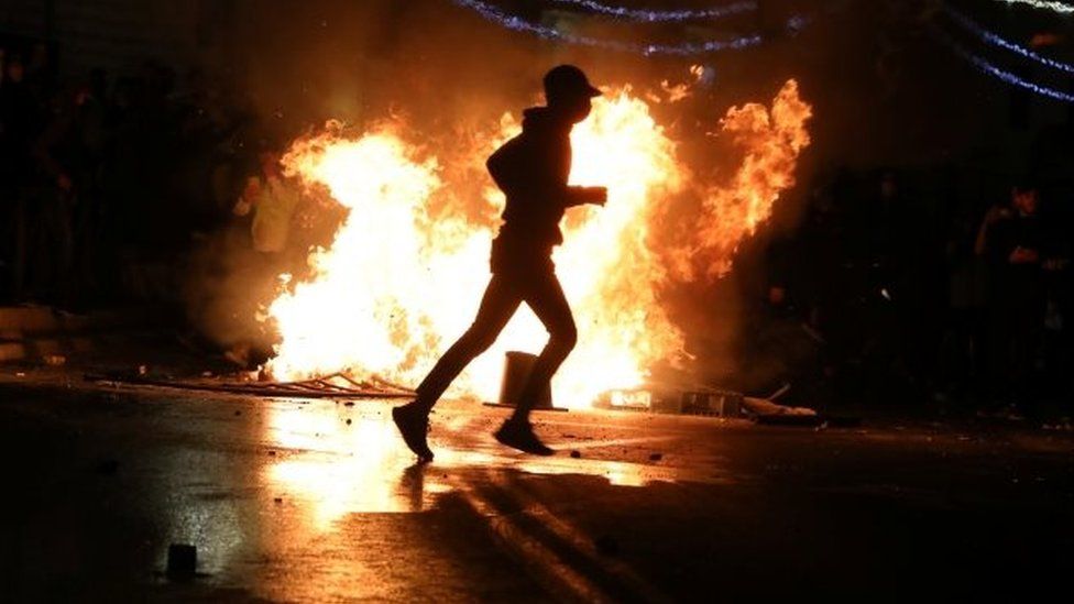 A protester runs in front of a burning barricade in Jerusalem, Israel. Photo: 22 April 2021