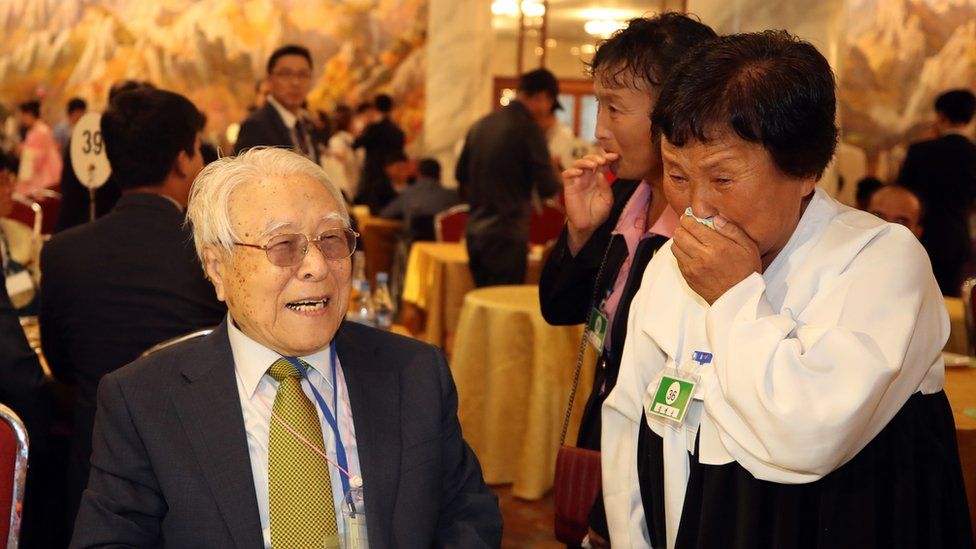 101-year-old Paek Seong-gyu (L) smiles as he meets his granddaughter Baek Yong-ok (R)