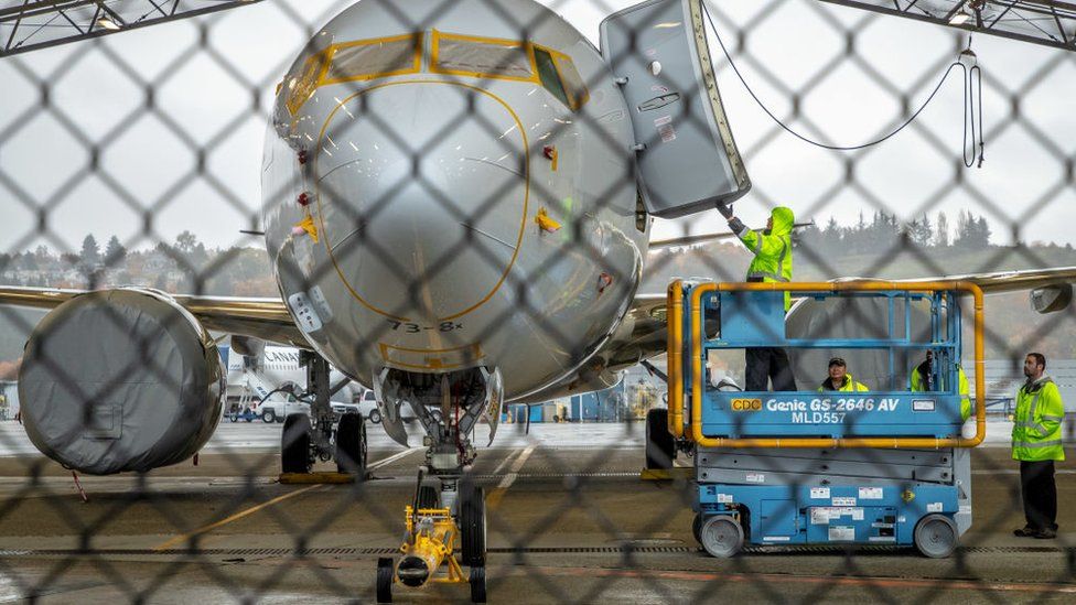 Workers inspect a Boeing 737 MAX aircraft owned by American Airlines