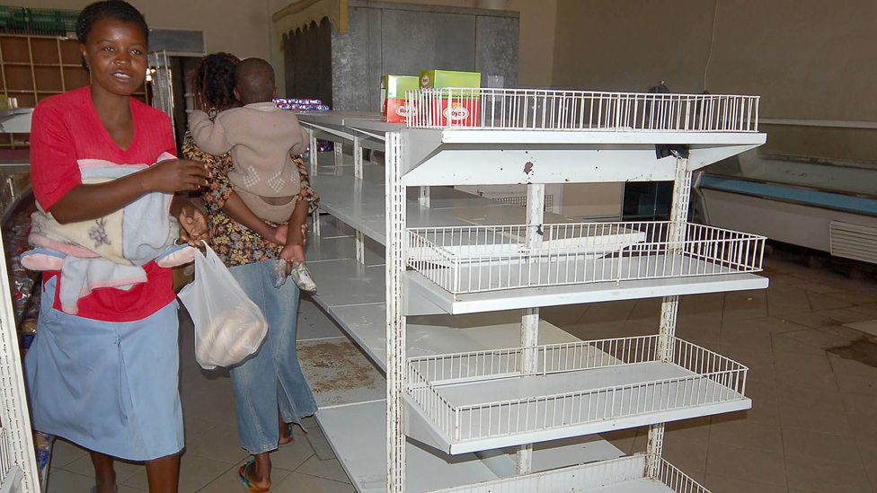 Harare shoppers walk past empty shelves in 2007