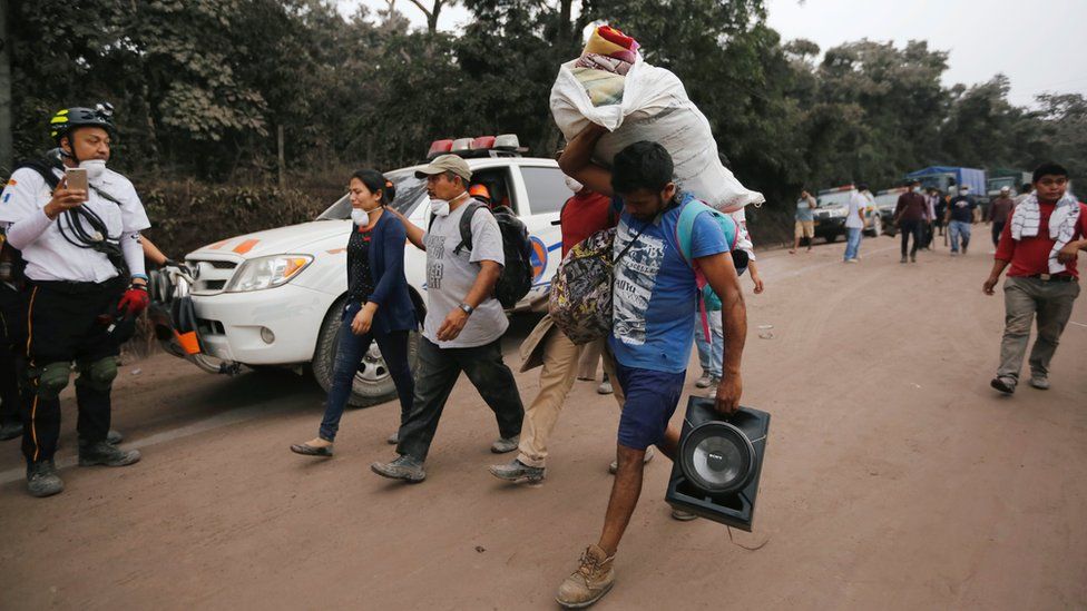 A man carries belongings from an area affected by an eruption from Fuego volcano in the community of San Miguel Los Lotes in Escuintla, Guatemala (June 4, 2018)