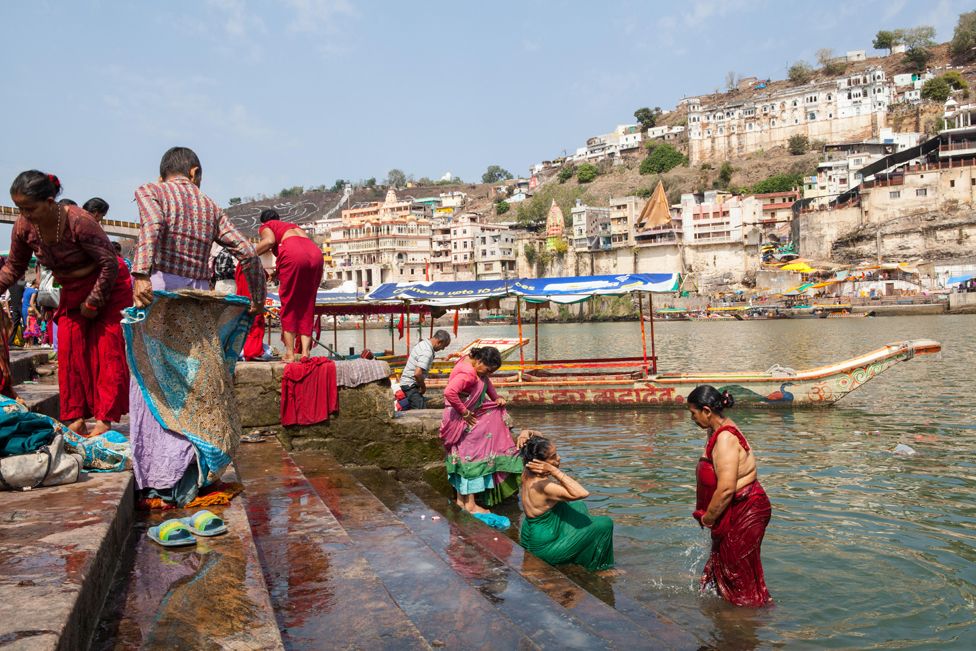 Pilgrims bathe in the Narmada River on the ghats at Omkareshwar