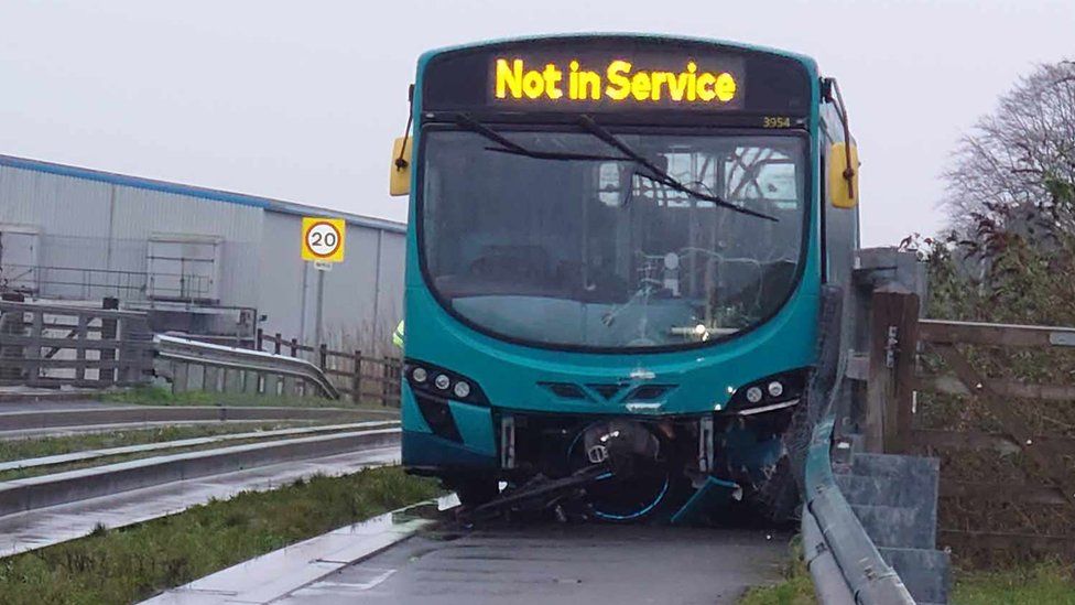 A 'not in service' bus parked on a cycle path with a bicycle sticking out of the front