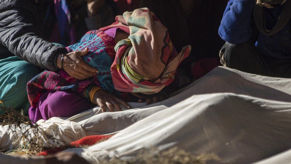 A relative mourns over bodies of victims during cremation procession at Chiuri village in Jajarkot, Nepal, 05 November 2023.