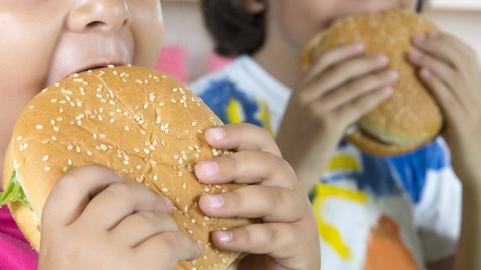 Two children eat burgers