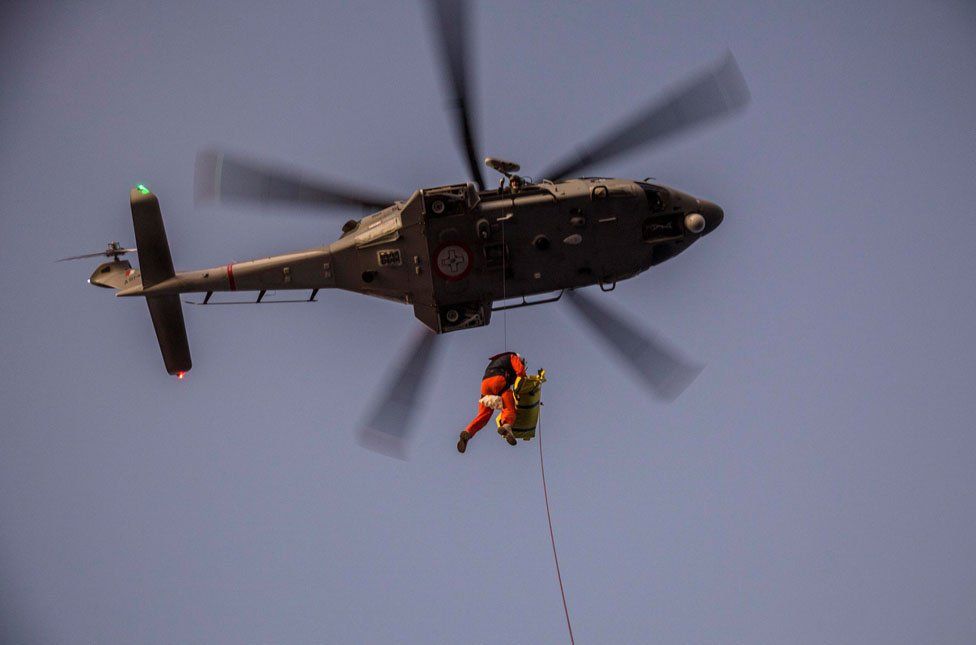 A rescue helicopter evacuates a mother and her new born baby after being rescued with other nearly 300 migrants off the coast of Libya on December 21, 2018 by Proactiva Open Arms organisation