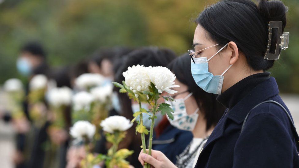 People observe a moment of silence to pay tribute to martyrs at Yuhuatai Martyrs Cemetery during Qingming Festival.